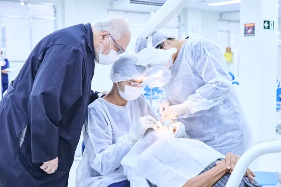 Professor orienta estudantes durante atendimento na clínica-escola